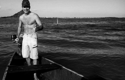 Portrait of shirtless man standing in sea against clear sky