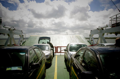 Cars on road against cloudy sky