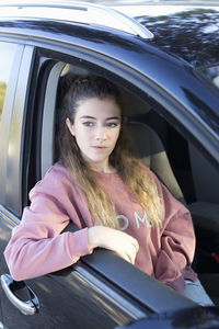 Teenage girl looking through window while sitting in car