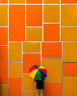 Rear view of woman standing against multi colored wall