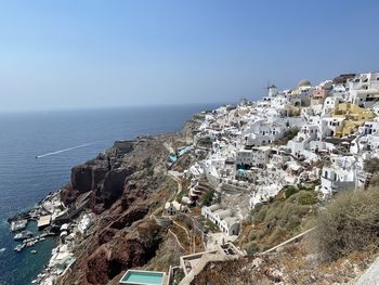 High angle view of townscape by sea against clear sky