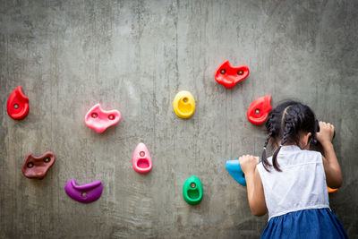 Rear view of woman standing against heart shape on wall