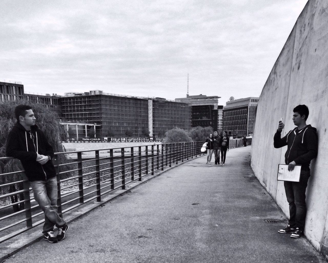 lifestyles, architecture, building exterior, full length, built structure, sky, leisure activity, men, walking, casual clothing, city, railing, person, cloud - sky, togetherness, rear view, city life, boys