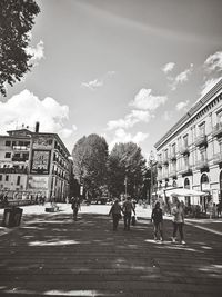 People walking on street against buildings in city