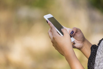 Cropped hands of woman using mobile phone