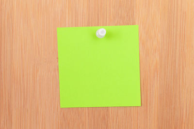 Close-up of green colored pencils on wooden table