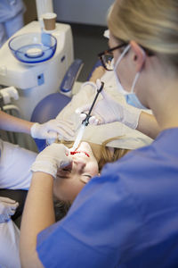 Young girl having dental filling at dentists office