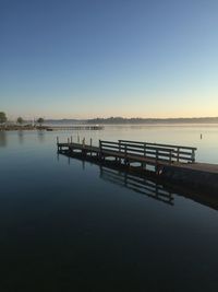 Pier on lake against clear sky during sunset