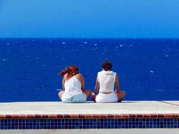 Rear view of women looking at sea