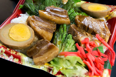 High angle view of boiled egg with pork and rice in plate