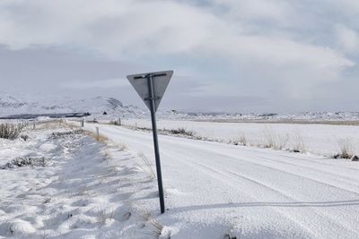 Road sign on snow covered field