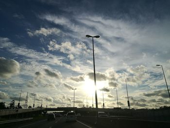 Low angle view of illuminated street lights against sky
