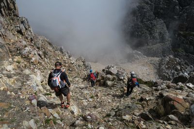 People on mountain against sky