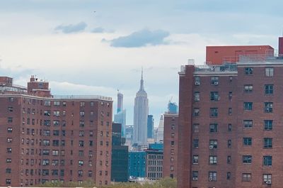 Buildings in city against cloudy sky