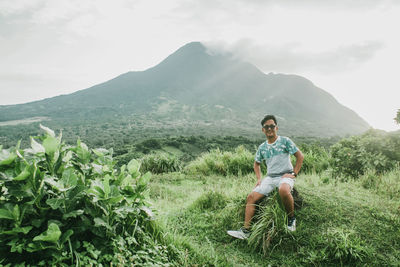 Young man on mountain against sky