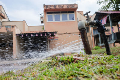 Water flowing outside house in yard against sky