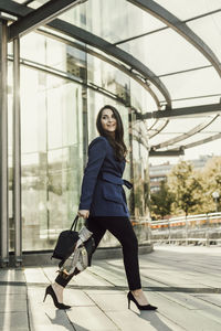 Businesswoman walking, office building in background