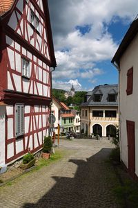 Footpath amidst buildings in town against sky