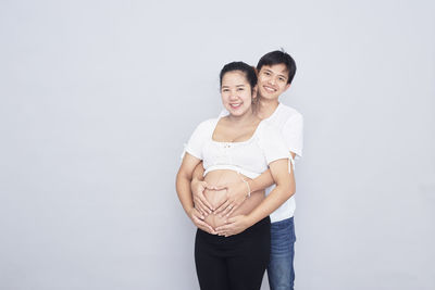 Portrait of a smiling young couple against white background