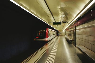 Train arriving at illuminated subway station