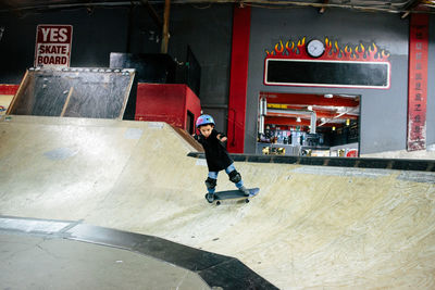 A boy turns his board around while skateboarding in skatepark