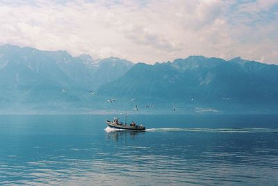 Fishing boat in lake against sky