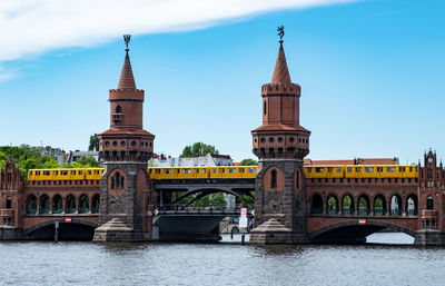 Arch bridge over river against buildings