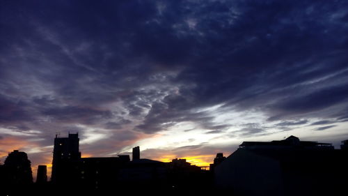 Silhouette of building against cloudy sky