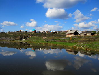 Scenic view of lake by buildings against sky