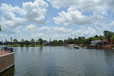 Scenic view of river by buildings against sky