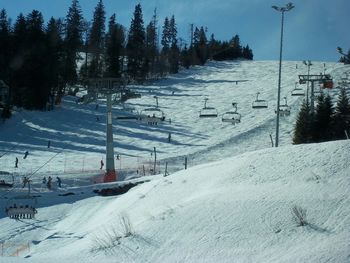 Cable cars on snow at snow covered landscape