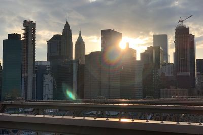 Modern buildings in city against sky during sunset