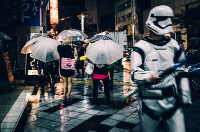 Rear view of people walking on wet street