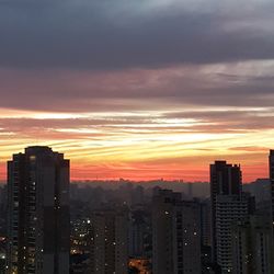 View of cityscape against cloudy sky during sunset