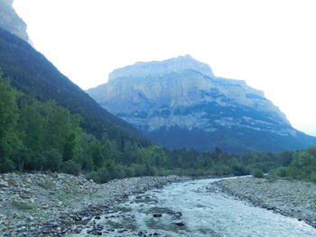 Scenic view of river amidst mountains against clear sky