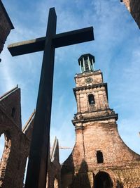 Low angle view of cross on building against sky