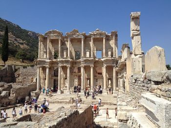 People at library celsus against clear blue sky