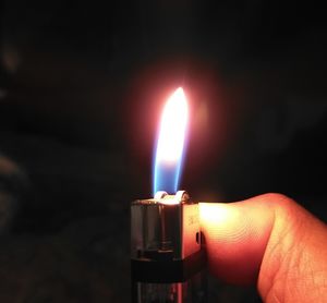 Close-up of hand holding lit candle