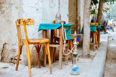 Hookah by wooden chairs and table on footpath