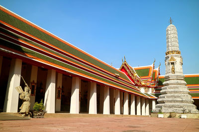 Cloister of wat pho temple with phra prang pagoda and chinese guardian statue, bangkok, thailand