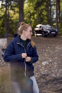 Smiling woman holding bag while looking away