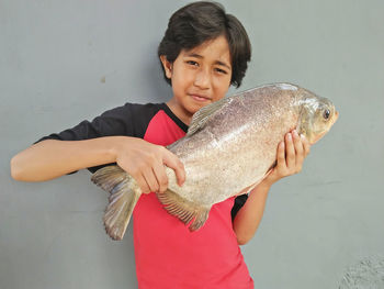 Portrait of a boy  holding fish after fishing