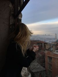 Side view of woman standing against sky