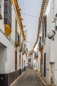 Narrow street amidst buildings against sky