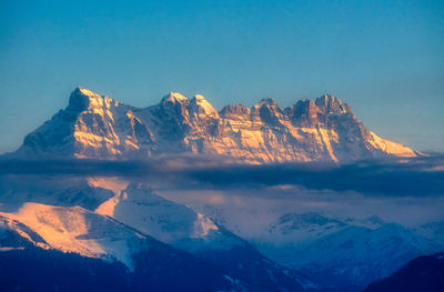 Scenic view of snowcapped mountains against blue sky