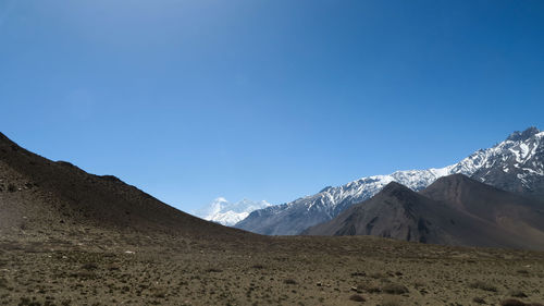 Scenic view of snowcapped mountains against clear blue sky