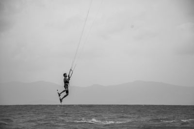 Young man kiteboarding over sea
