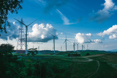 Windmills on field against sky