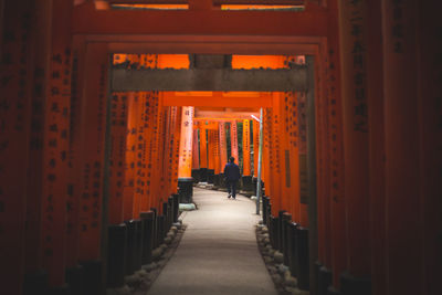 Rear view of man walking in corridor of temple 