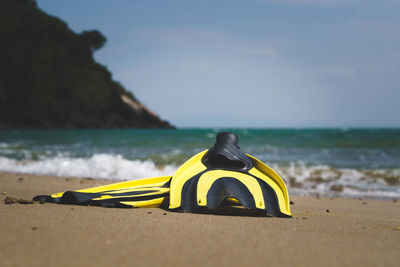 Yellow umbrella on beach against sky